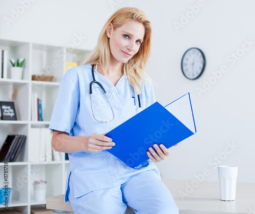 Young female doctor and practitioner working at desk