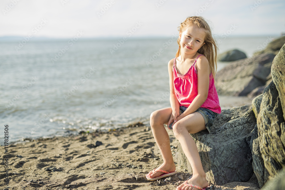Cute little girl standing close to beach at sunset Cute little girl standing close to beach at sunset