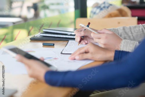  female hands with pen writing on notebook coffee cafe