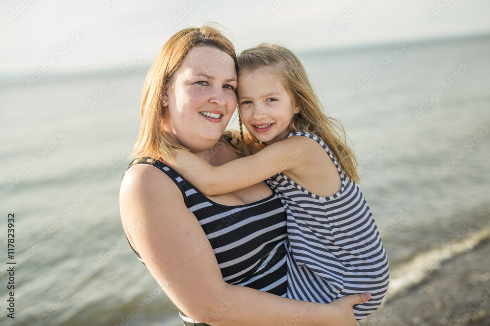 Mother and daughter on the beach side having fun Mother and daughter on the beach side having fun