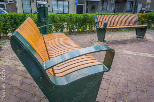 two modern city benches with a trash can