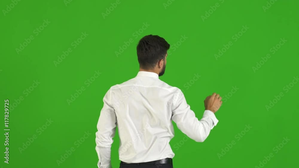 The businessman touch the virtual screen on the green background. Real time capture