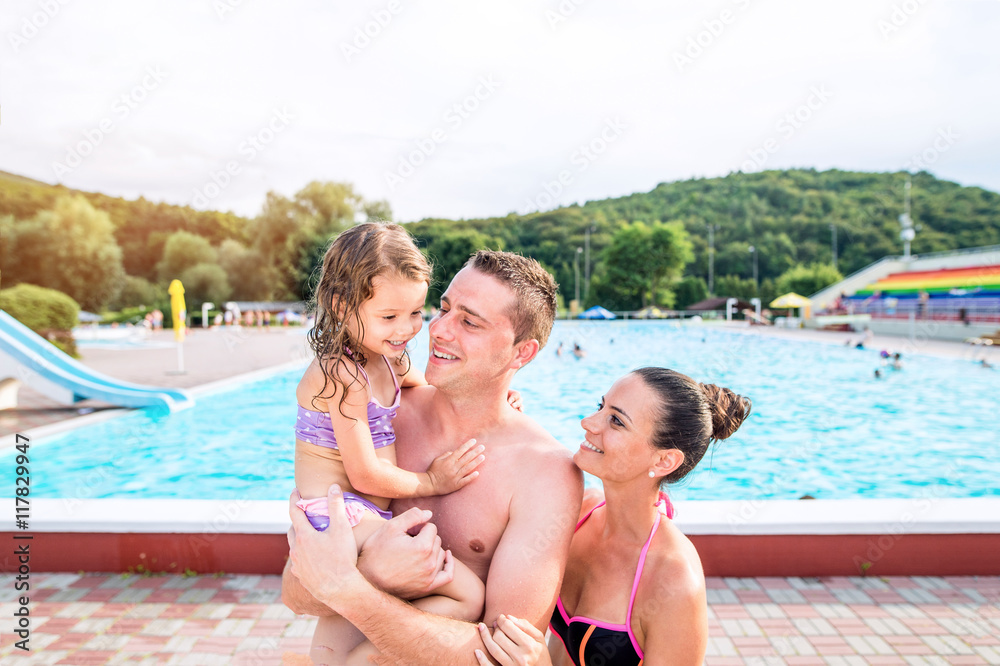 Mother, father and daughter near swimming pool. Sunny summer. Mother, father and daughter near swimming pool. Sunny summer.