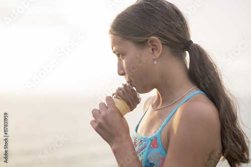 Woman eating a delicious ice cream on the sunset.