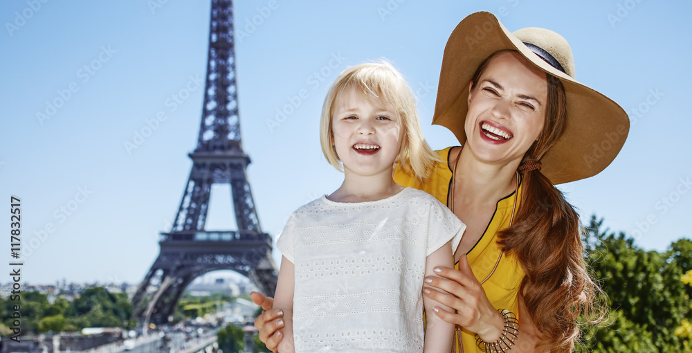mother and daughter tourists standing in front of Eiffel tower