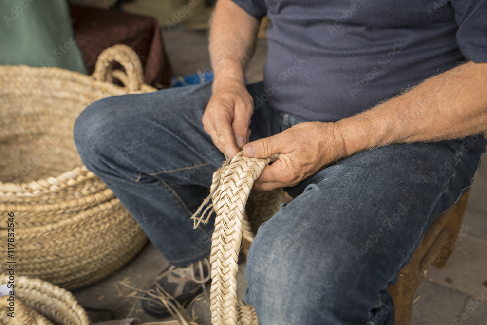 Fototapeta premium hand man weaving a wicker basket