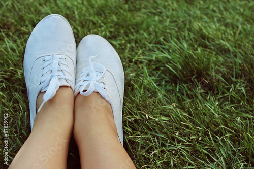 white sneakers on a background of green grass - summer
