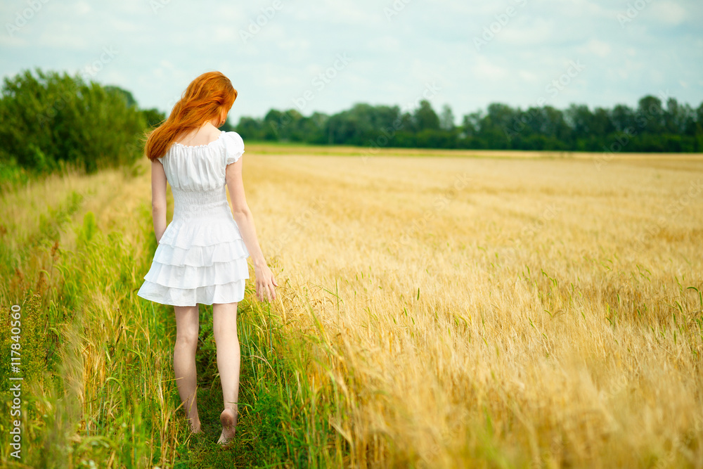 Young girl walking through field Young girl walking through field