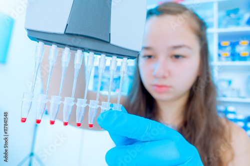 Fotografie Young female scientist loads samples for DNA amplification by PCR