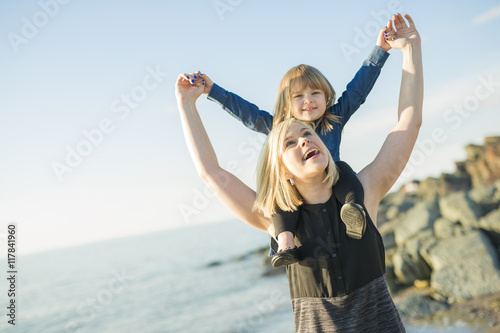 Mother and daughter on the beach side having fun