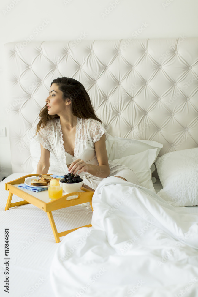 Pretty young woman having a breakfast in the bed Pretty young woman having a breakfast in the bed