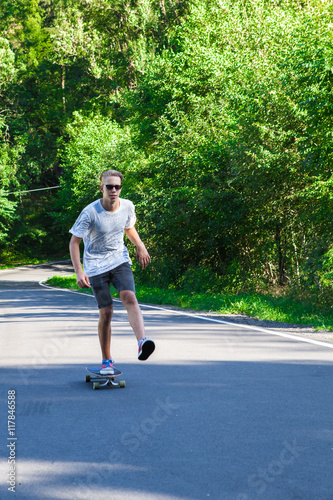Young men on the longboard on road