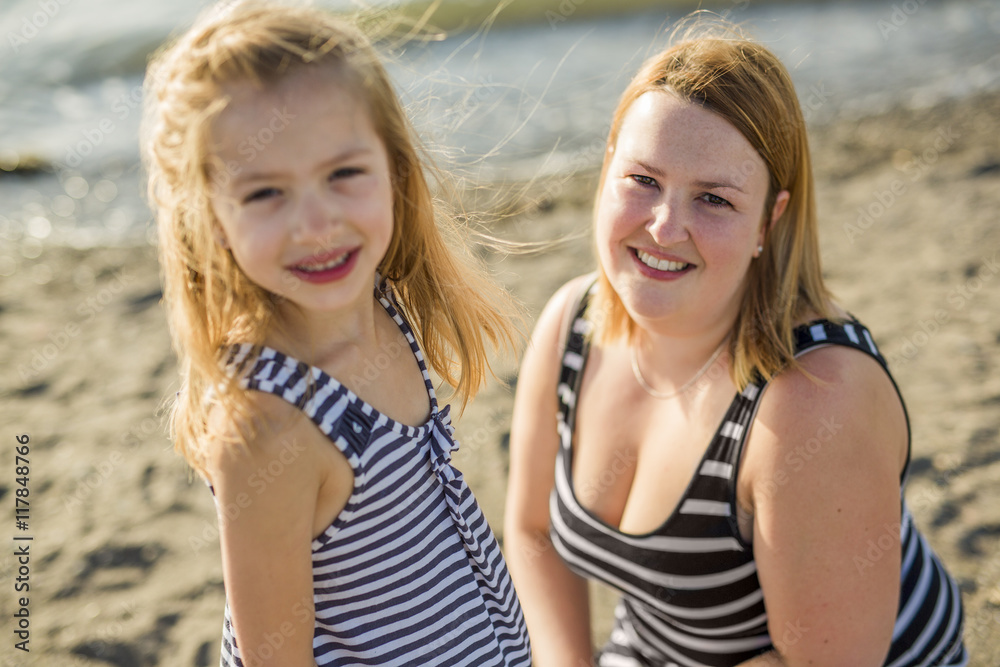 Mother and daughter on the beach side having fun Mother and daughter on the beach side having fun