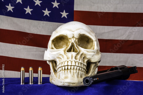 human skull on blue with three bullets and 357 magnum revolver and american flag background photo