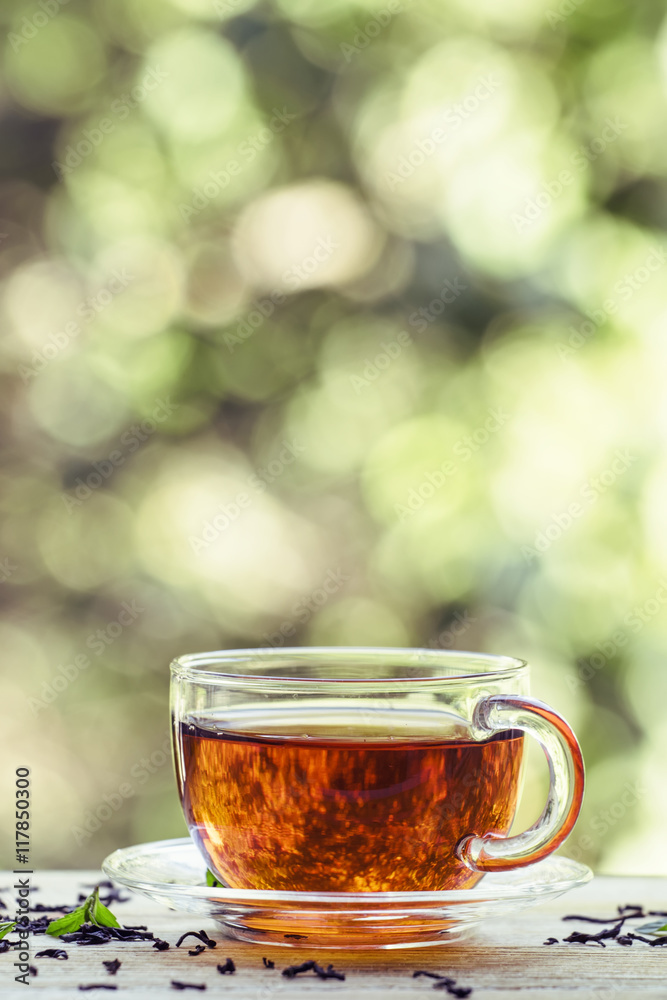 Cup of black tea on the open window on green blurred nature back Cup of black tea on the open window on green blurred nature back