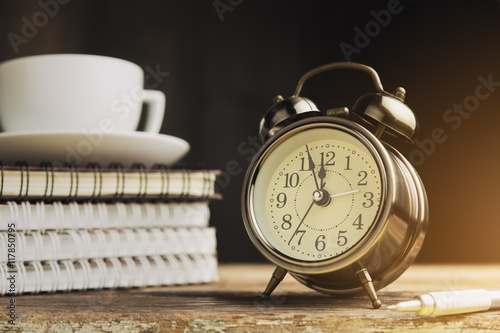 Vintage alarm clock on a table. Photo in vintage color image sty