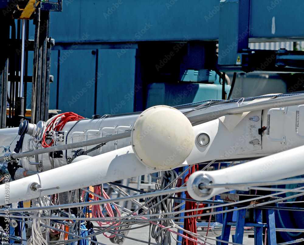 A mast of a sailing boat is moved from a mobile crane. A mast of a sailing boat is moved from a mobile crane.