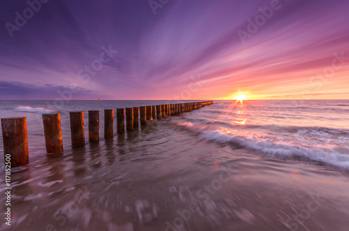 Fototapeta Naklejka Na Ścianę i Meble -  Baltic sea coast on colorful sunset with wooden groyne, Poland