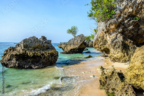 seaside beach by a cliff and with rocks in the water, horizontal 