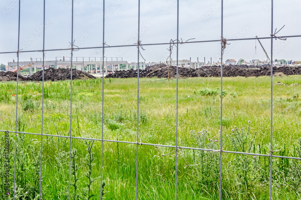 View on the construction site through a fence wire