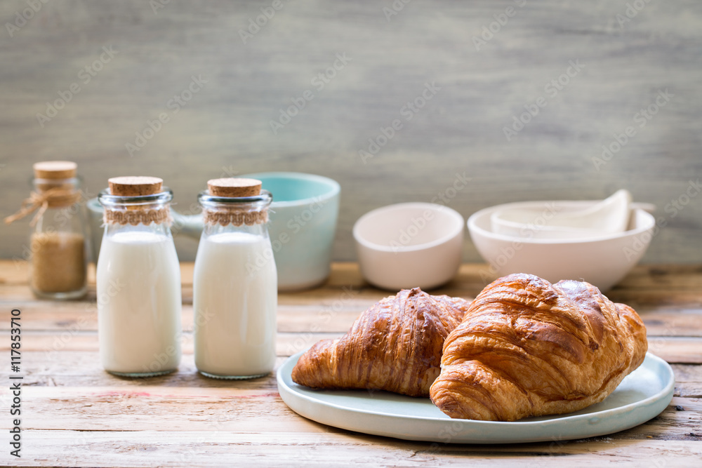 Delicious breakfast with fresh croissants and milk on old wooden background Delicious breakfast with fresh croissants and milk on old wooden background