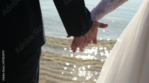 Newly married couple on tropical beach after sunset wedding, Romantic bride and groom