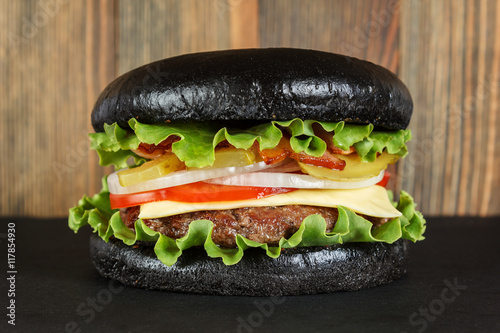 Black burger on wood background