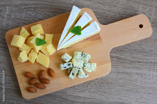 Different sorts of cheese on wooden plate photo