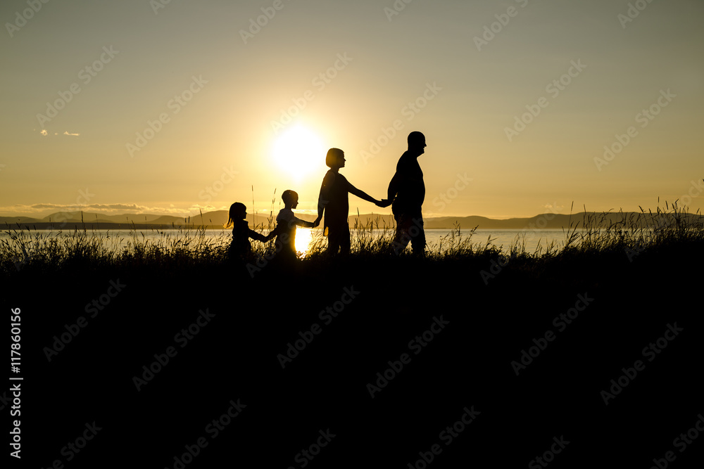 family of four at sunset shadow black backlit