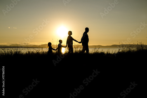 family of four at sunset shadow black backlit