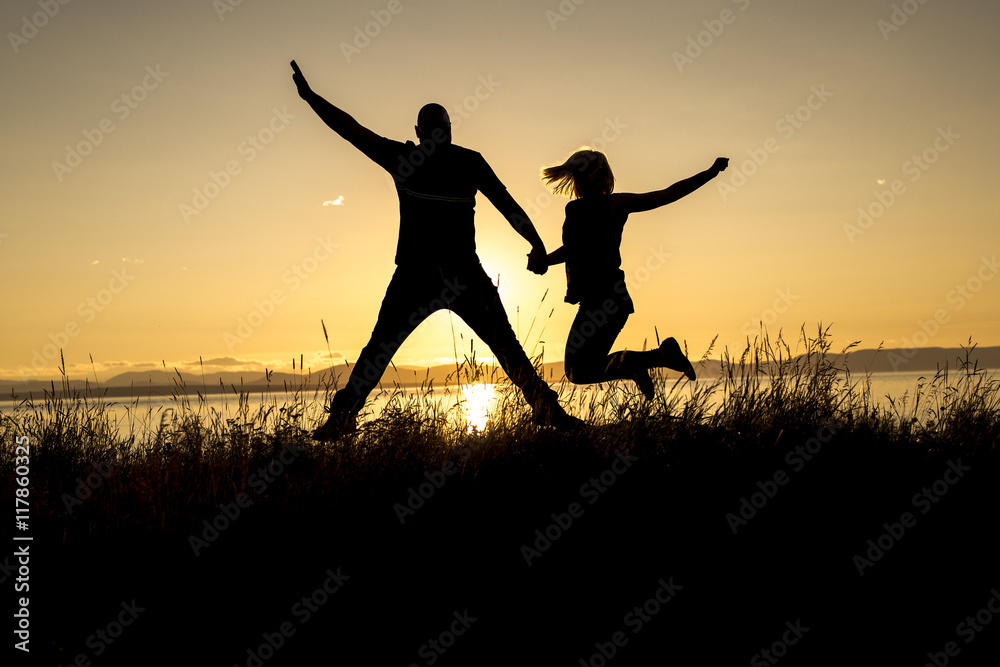 Silhouettes of romantic couple on tropical beach at sunset Silhouettes of romantic couple on tropical beach at sunset