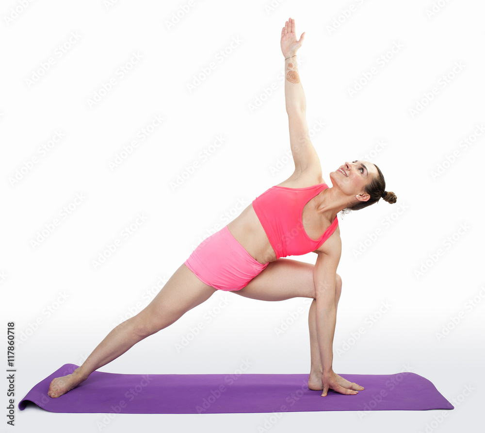 Young brunette woman doing pilates exercises on mat isolated Young brunette woman doing pilates exercises on mat isolated