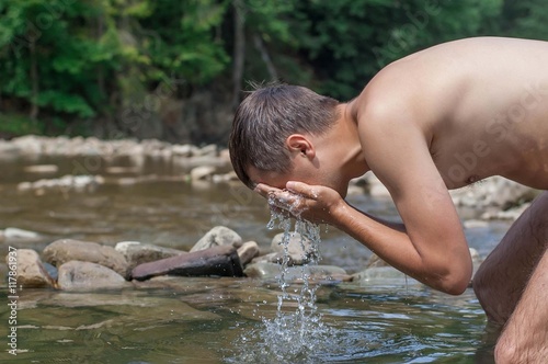 Man washing face in river