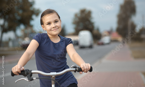 Cute girl is sitting on bicycle