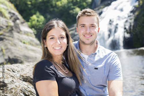 Young couple in love with waterfall on background