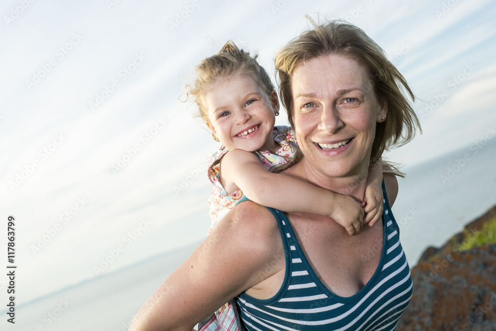 Mother and daughter on the beach side having fun Mother and daughter on the beach side having fun