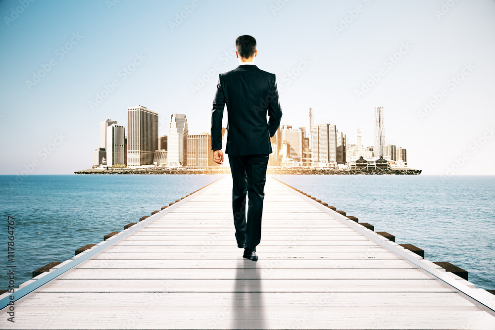 Businessman walking towards city