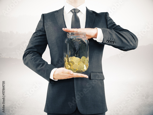 Man holding jar with coins
