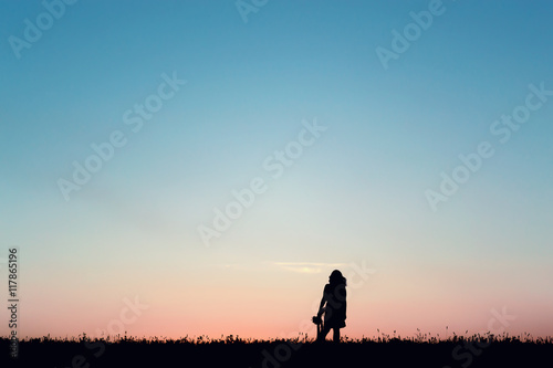 Silhouette of a beautiful girl jumping over sunset © callisto