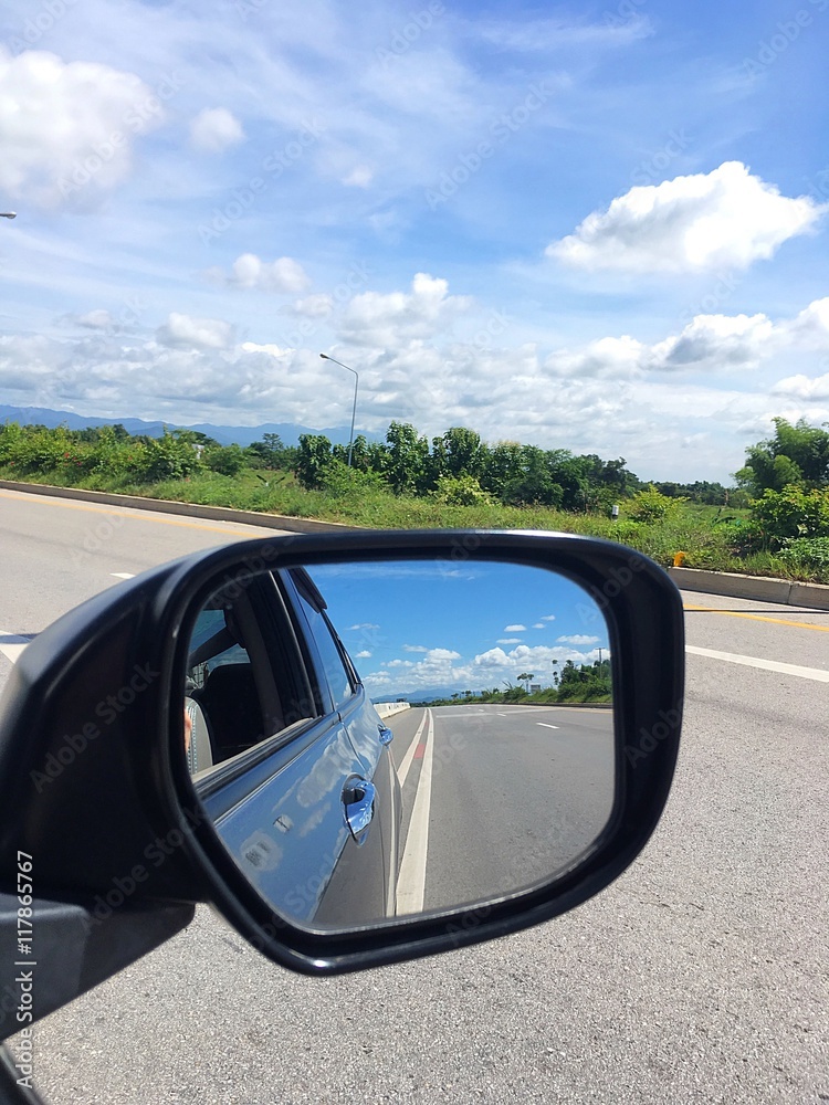 Car rearview mirror reflection on the road