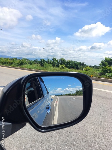 Car rearview mirror reflection on the road