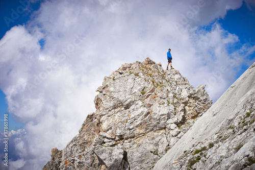 man reaching peak / standing on top of mountain