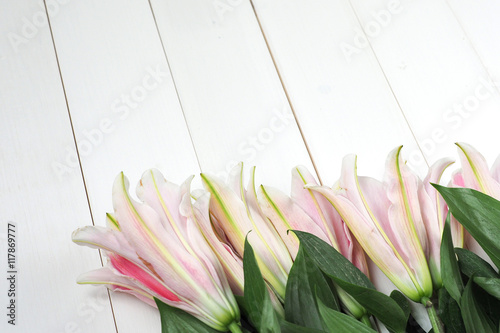 Fototapeta Naklejka Na Ścianę i Meble -  Lily flowers arranged on table top white wood board