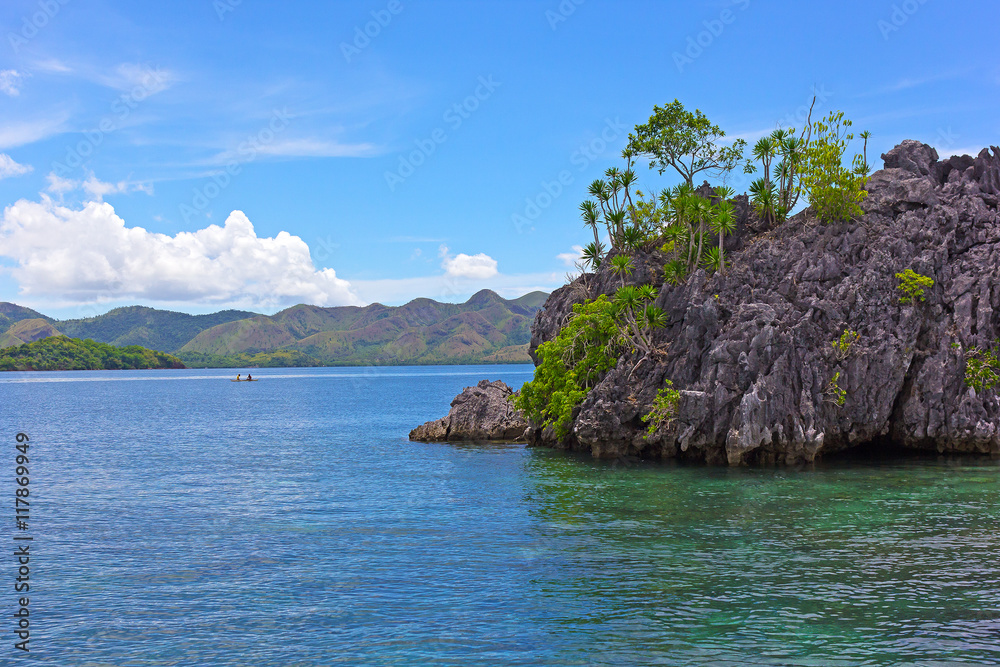 Sea waters of Coron Island lagoon with mountains on horizon, Philippines. Tropical island landscape with the boats in a view.