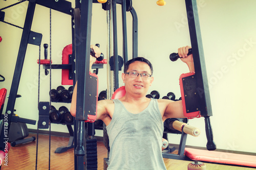 Asia man middle aged training arm equipment in the gym for strength, weight loss.