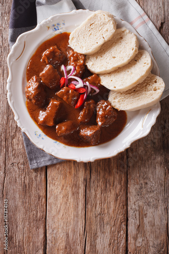 homemade hot Czech goulash with knodel close-up. vertical top view
