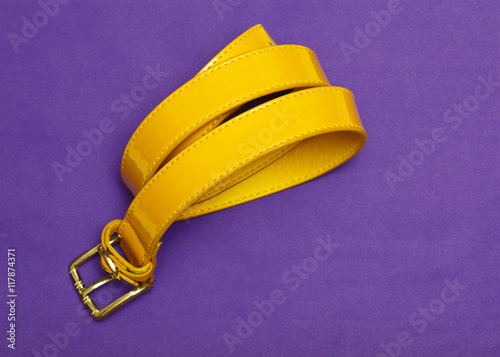 rolled up lady belt isolated on violet background top view