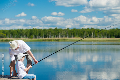 Dad teaches his son on the nature to fish