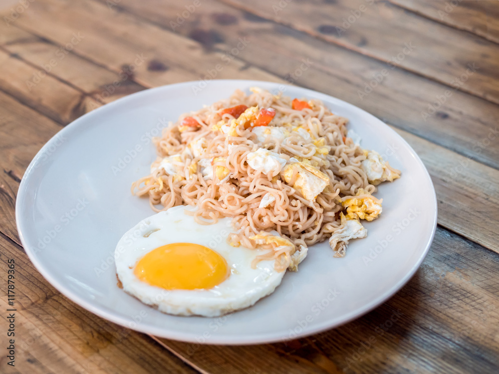 delicious noodle with sunny up fried egg on the wood table delicious noodle with sunny up fried egg on the wood table