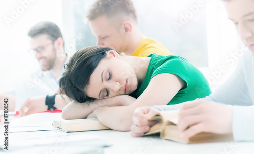 Tired girl sleeping on a lesson. Depression concept